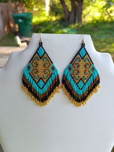 These Native American Style Beaded Turquoise, Gold, Bronze Earrings. They are about 4 inch long with Gold wires on them, can be changed to post, clips or lever backs . If you like them but want other colors just email me. If you have any Questions please ask.  Thanks for looking. Long Turquoise Earrings, Fringed Earrings, Native American Style, Bronze Earrings, Earrings Bohemian, Native American Fashion, Brick Stitch, Gold Wire, Fringe Earrings