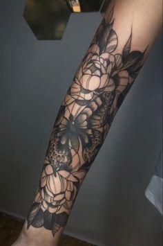 a woman's arm with black and white flowers on the inside of her leg