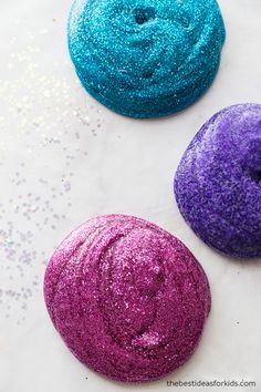 three donuts covered in glitter sitting next to each other