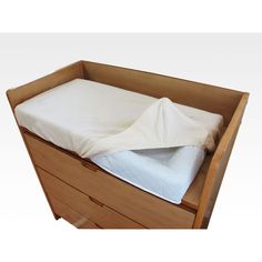 a bed with a white sheet on top of it in a wooden drawer next to a pillow