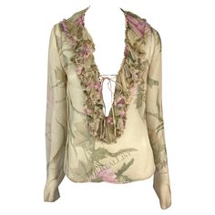 Presenting a fabulous tan sheer Gucci ruffle top, designed by Tom Ford. From the Spring/Summer 2003 collection, this chic top is covered in a bold floral print. Entirely sheer, the top features a plunging neckline framed by a ruffle accent that wraps around the neck. The top is made complete with long sleeves and a tie closure at the bust. Approximate measurements: Size - 44IT Shoulder to hem: 23" Bust: 36" Waist: 34" Shoulder to cuff: 27" Underarm to cuff: 22" Materials tag removed. Spring Fitted Gucci Shirt, Chic Luxury Gucci Tops, Gucci Fitted Luxury Blouse, Fitted Gucci Top For Night Out, Gucci Long Sleeve Party Tops, Elegant Silk Gucci Tops, Fitted Gucci Top With Button Closure, Gucci Sleeveless Fitted Top, Gucci Blouse