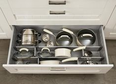 an open drawer with pots and pans in it