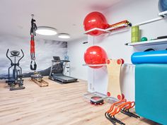 a gym with exercise equipment and yoga mats on the floor in front of a wall mural