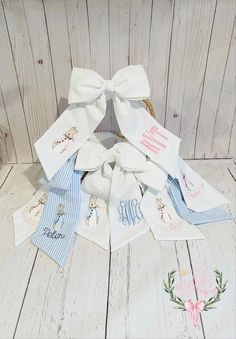 a bunch of white and blue ribbons on top of a wooden floor next to a teddy bear