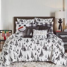 a bed with black and white christmas trees on the comforter, pillows and pillowcases