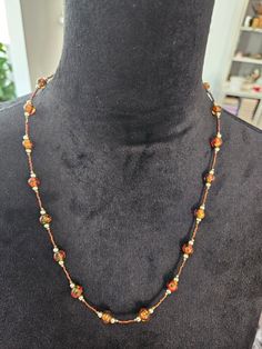 "24\" necklace  Round glass beads filled with orange,  gold, and green. The colors are subtle,  so they just form a nice blend inside the bead.  Magnetic closure Great for any casual or office attire.  This necklace is in very good condition.  All of my merchandise comes from a smoke-free environment.  Thank you for visiting my shop❣️" Orange Glass Beaded Necklace With Colorful Beads, Orange Glass Beaded Jewelry, Orange Beaded Glass Necklaces, Handmade Orange Glass Necklaces, Handmade Orange Glass Necklace, Elegant Orange Beaded Crystal Necklace, Orange Glass Necklace With Colorful Beads, Adjustable Orange Czech Glass Necklace, Orange Glass Beaded Necklace For Gift