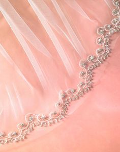 a close up view of the back of a wedding dress with beaded details on it