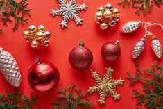 christmas ornaments are arranged on a red surface