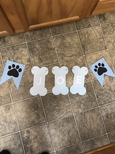 some paper cutouts that say love and bear feet on a tile floor in front of a door