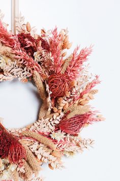 a wreath made out of dried flowers and leaves