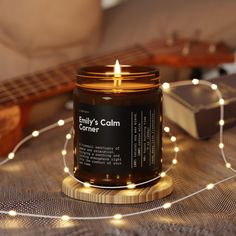 a candle sitting on top of a table next to a string of lights and a guitar