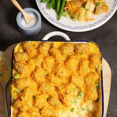 a casserole dish with green beans and cheese on it next to two plates