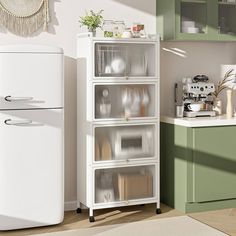 a white refrigerator freezer sitting next to a green cabinet in a kitchen with wooden floors