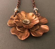 "Three layers of copper that were cut, hand hammered for texture then cold connected and topped with a silver center. The flower is 1.75\" across. The piece is suspended from a copper link chain that is joined to the pendant with a hand wired metal bead. The chain including the bead is 20\". The chain has a copper lobster claw closure. The flower was oxidized to bring out all of the hand texturing on the petals. The flower was also given an acrylic coating to finish it. NC1289" Purple Flower Necklace, Purple Pendant Necklace, Copper Work, Peacock Jewelry, Hammered Jewelry, Copper Jewellery, Blue Peacock, Metal Bead, Copper Pendant