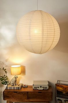 a lamp that is sitting on top of a wooden table next to a book shelf