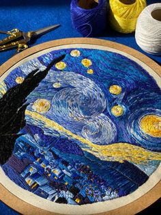 the starry night has been made with yarn and crochet hooks, along with two spools of thread