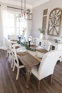 the dining room table is set with white chairs and place settings for four people to sit at