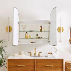 a bathroom vanity with two sinks and gold faucets on the mirror above it