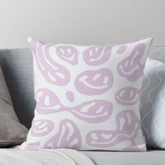 a pink and white pillow sitting on top of a couch