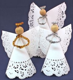 paper angel decorations with rings and beads on them