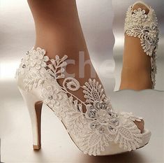 a pair of white high heeled shoes with lace and flowers on the heels are shown