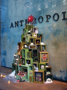 a christmas tree made out of boxes and other items in front of an antopolite sign