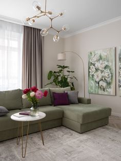 a living room filled with furniture and flowers on top of a white table in front of a window