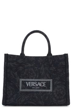 The label's signature Barocco pattern and an embroidered logo decorate this structured tote in a perfect everyday size. A removable, matching shoulder strap adds a hands-free carrying option to the classic style. Open top Top carry handles; removable, adjustable shoulder strap Exterior slip pocket Interior zip pocket Structured silhouette with flat base and protective leather feet Unlined Textile with leather trim Made in Italy Designer Handbags Elegant Top Handle Shoulder Bag With Embroidered Logo, Luxury Shoulder Bag With Embroidered Logo For Daily Use, Luxury Bags With Embroidered Logo For Daily Use, Luxury Tote Bag With Embroidered Logo, Luxury Shoulder Bag With Engraved Logo And Double Handle, Elegant Double Handle Bag With Embroidered Logo, Luxury Double Handle Shoulder Bag With Engraved Logo, Luxury Double Handle Shoulder Bag With Embroidered Logo, Black Top Handle Shoulder Bag With Embroidered Logo