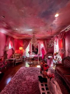 the living room is decorated in pink and purple tones with chandeliers on either side