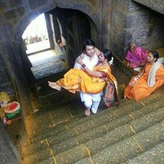 some people are sitting on the stairs and one is holding another person in her arms