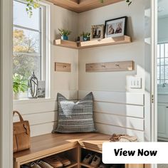 a wooden bench sitting under a window next to a shelf filled with shoes and other items