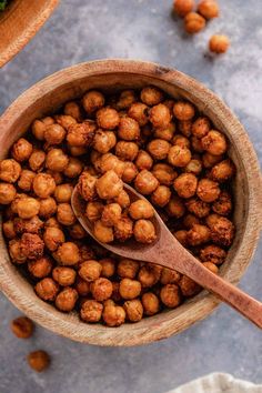 a wooden spoon in a bowl filled with chickpeas