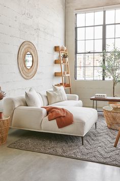 a living room filled with furniture and a white couch in front of a large window