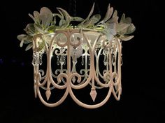 a white chandelier with flowers hanging from it