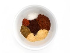 a white bowl filled with spices on top of a table