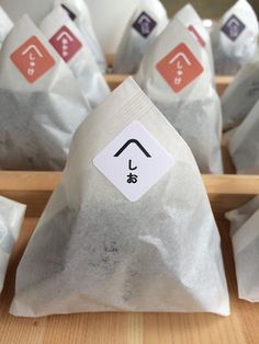 several bags of tea sitting on top of a wooden table next to some chopsticks