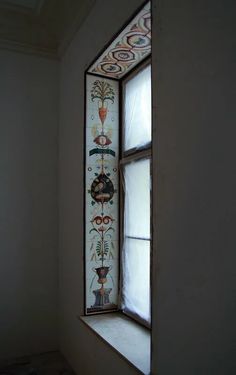 an old stained glass window in the corner of a room