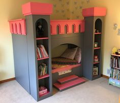 a child's bedroom with a castle bed and bookshelf in the corner