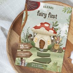 a wooden plate with a fairy first birthday card on it and a mushroom house in the middle