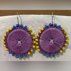 purple and yellow beaded earrings on white cloth