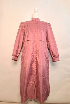 "Vintage Chiango by fleet street 80's pink trench coat.  Amazing coat that will make you want to play in the weather.  Six button snaps for closure.  Button snaps on cuffs, built in shoulder pads, as well as additional lining for extra warmth that can be removed.  Comes with matching waist belt.   Outershell is 100% polyester face, 100% rubber back, lining is nylon, filling is 100% polyester.  Marked size 14, in great vintage condition!   *Please double check measurements to make sure it's a goo Oversized Pink Outerwear With Button Closure, Spring Long-sleeved Raincoat With Button Closure, Spring Long Sleeve Raincoat With Button Closure, Spring Raincoat With Button Closure For Rainy Weather, Oversized Pink Outerwear For Daywear, Pink Oversized Outerwear For Daywear, Pink Raincoat For Fall Rainy Weather, Pink Fall Raincoat For Rainy Weather, Solid Color Raincoat With Button Closure For Spring