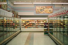 an empty grocery store aisle with lots of food in the aisles and on display shelves