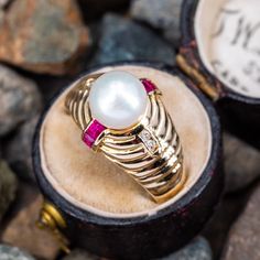 This charming pearl ring is crafted of 14k yellow gold and centered with one cultured pearl. The ring features channel set rubies and diamonds accents on the stepped shoulders. This ring is currently a size 7. Rubies And Diamonds, Saltwater Pearls, Ruby Diamond, Channel Set, Ruby Ring, October Birth Stone, Pearl Ring, High Quality Jewelry, Modern Jewelry