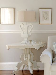 a white couch sitting next to a table on top of a hard wood floor