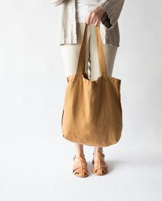 a woman is holding a brown bag in front of her legs and shoes, with the words albabatis on it