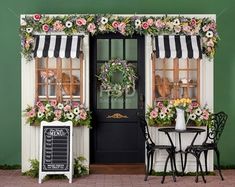 an outside cafe with flowers on the awnings and tables in front of it