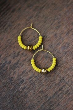 Cute summer earrings with bright lemon yellow glass seed beads,gold tone sphere beads and gold tone stainless steel round hoop earrings. Earring hooks are from nickel free and lead free metal. Perfect jewelry for everyday wear or a great gift for someone special! Diameter of hoops is 20 mm. Other earrings of my shop you can see here: https://www.etsy.com/shop/NaTavelli?section_id=13757927 Thanks for visit. Earring Simple, Minimalist Summer, Earring Hoops, Earring Ring, Ring Earring, Small Beads, Earring Gold, Yellow Earrings, Summer Earring