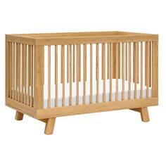 a small wooden crib with white sheets on the bottom and side rails, in front of a white background