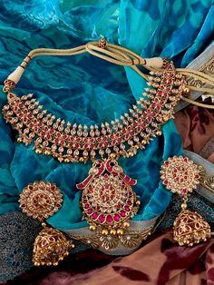 Experience opulence with our exquisite jewelry set, crafted by the same skilled artisans who create real gold pieces. Fashioned from top-quality materials, it mirrors the allure of genuine gold without the price tag. Perfect for destination weddings and parties, its elegance is matched only by its convenience and security for travel. Product Details: Material: Each piece is meticulously handcrafted from high-quality brass and Kundan Stones. Necklace Dimensions: Weight: 85 grams Closure Type: Pre Hand Set Yellow Gold Round Kundan Necklace, Luxury Stone Work Jewelry For Festive Season, Luxury Stone Work Jewelry Sets For Formal Occasions, Luxury Wedding Jewelry Sets With Stone Setting, Luxury Stone-set Jewelry For Wedding, Yellow Gold Plated Kundan Necklace, Temple Jewelry Sets With Round Stone Setting, Elegant Ruby Kundan Necklace With Stone Work, Luxury Stone Work Jewelry Sets For Festive Occasion