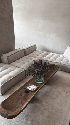 a living room with a couch, coffee table and vase on the floor in front of it